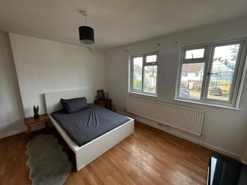 1 dormitorio con 1 cama y 2 ventanas en Waltham Cross Rooms, en Cheshunt