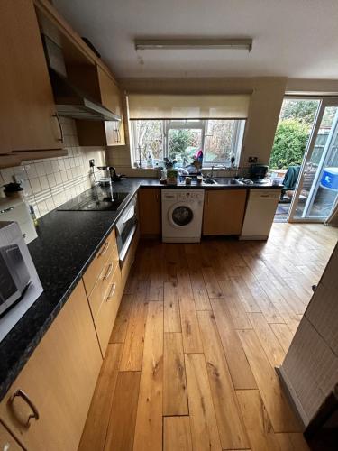 a kitchen with a sink and a washing machine at Waltham Cross Rooms in Cheshunt
