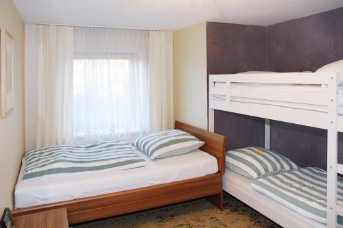 a bedroom with two bunk beds and a window at Wendelin`s Ferienwohnung in Wolfegg