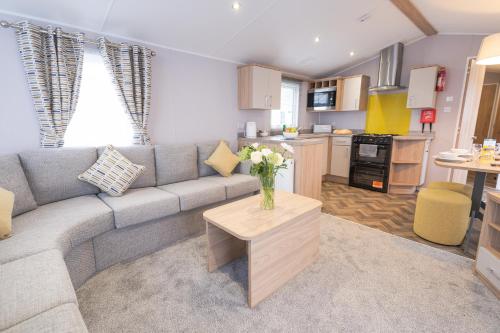 a living room with a couch and a vase of flowers at Marine Holiday Park in Rhyl