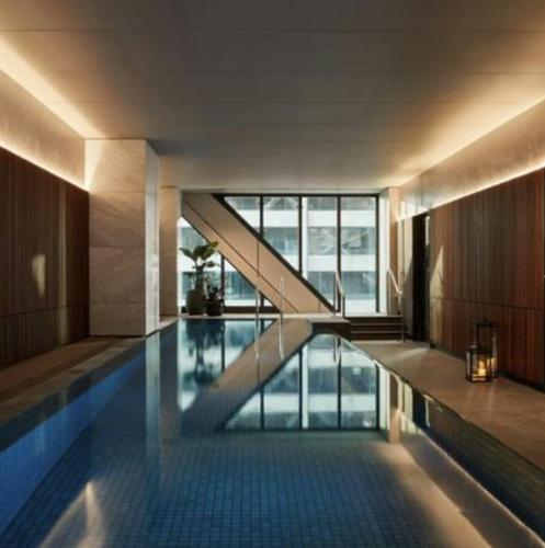 a swimming pool in a building with a large window at Paragon Apartment Penthouse Amazing Views, Spacious & Great Location in Melbourne