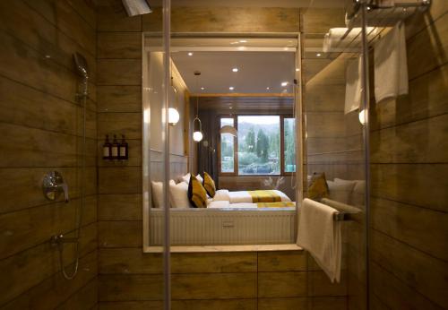 a bathroom with a mirror with a bed in it at Hotel Rewa Ladakh in Leh