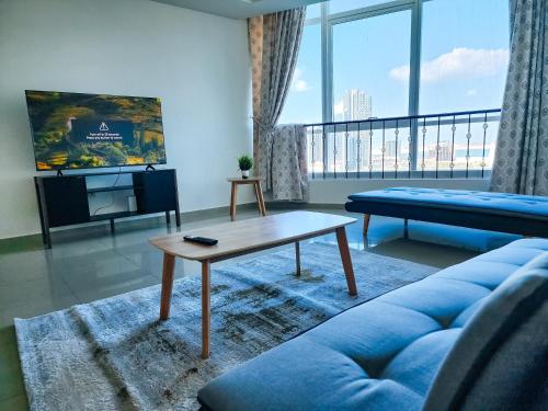 a living room with a blue couch and a coffee table at HARF4606 Huge water front 1BR Apt with 2 Sofa Beds in Alreem Island in Abu Dhabi