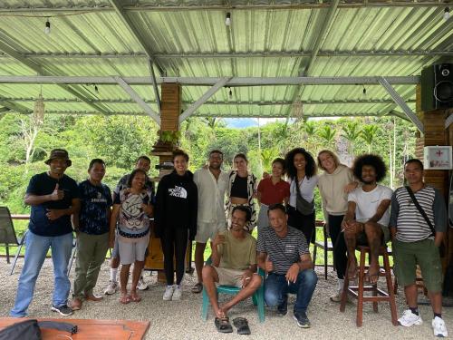 a group of people posing for a picture under ailion at Rago's Homestay in Kelimutu