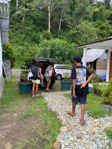 a group of people standing in front of a car at Rago's Homestay in Kelimutu