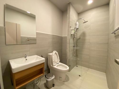 y baño con lavabo, aseo y ducha. en Double J Hotel, en Chiang Mai