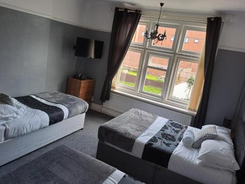 a bedroom with two beds and a window at Sheridans Budget Accomodation in Wallasey