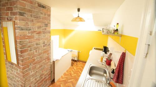 a kitchen with a sink and a brick wall at Medainie apartamenti in Liepāja