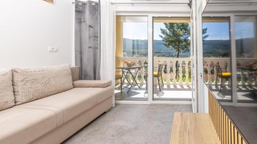 a living room with a couch and a balcony at Villa Vista in Jelsa