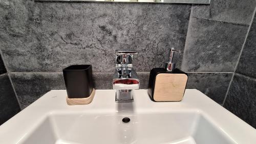 a bathroom sink with a soap dispenser and a bottle at bungalov na břehu Labe s vlastním molem in Pardubice