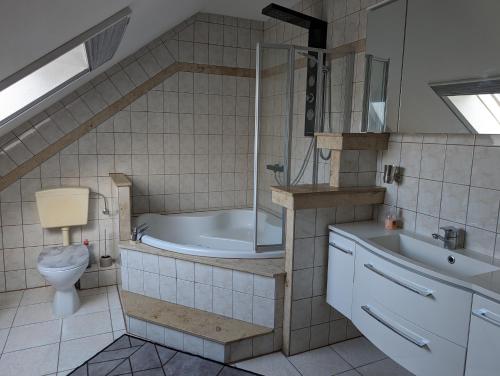 a bathroom with a tub and a toilet and a sink at Ferienwohnung Schusi Kesselsdorf in Kesselsdorf