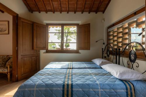 Schlafzimmer mit einem Bett mit blauer Decke in der Unterkunft ASSO DI PICCHE in Siena