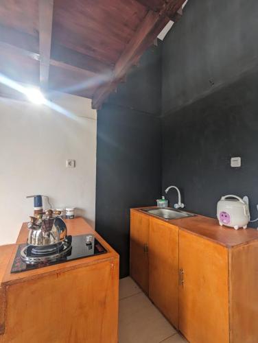 Il comprend une cuisine équipée d'une cuisinière et d'un évier. dans l'établissement Cottage Linggayoni Dieng 1, à Diyeng