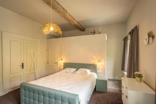 a bedroom with a bed with a blue tufted headboard at Leyselebeke Castle in Bruges