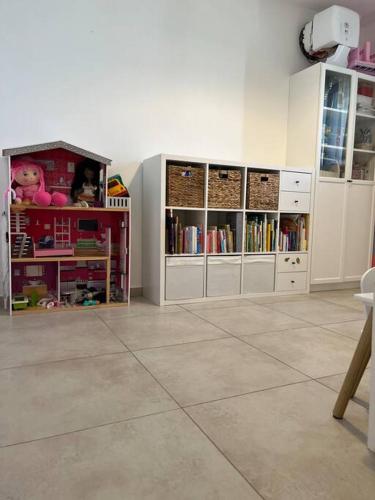 a room with white cabinets and a book shelf with books at בין הים לכרמל in Tirat Karmel