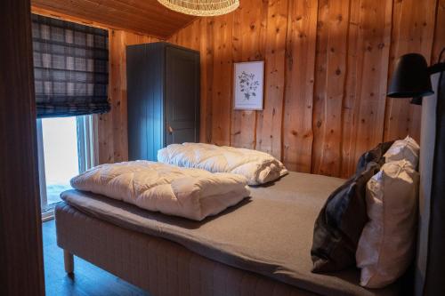 two beds in a room with wooden walls at Hytter Dombås in Dombås