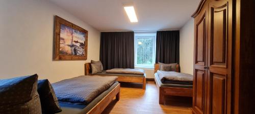Habitación pequeña con 2 camas y ventana en Gästehaus Hirschstein - Hochwertige Ferienwohnung in sehr ruhiger Lage direkt am Fluss Göltzsch, en Reichenbach im Vogtland