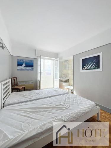 une chambre avec un grand lit blanc dans une pièce dans l'établissement Résidence Saint Pierre: Vue Mer, 2 Chambres, à Bray-Dunes