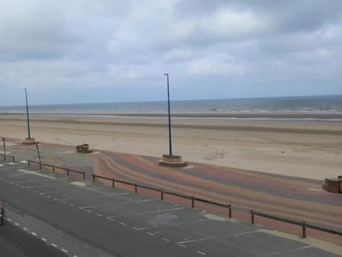 a road next to a beach with street lights at Digue de Mer - Appt Vue Mer, 2 Chambres in Bray-Dunes