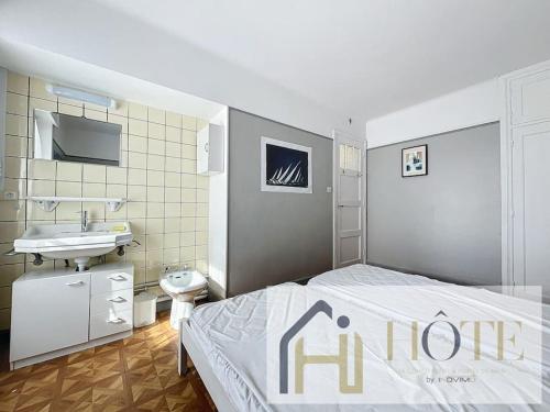 une petite salle de bain avec un lit et un lavabo dans l'établissement Résidence Saint Pierre: Vue Mer, 2 Chambres, à Bray-Dunes