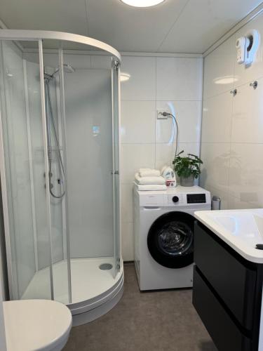 ein Bad mit einer Dusche und einer Waschmaschine in der Unterkunft Mini apartment in centre of Jørpeland in Jørpeland