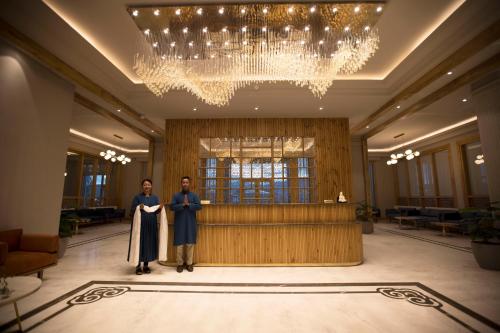 two people standing in the lobby of a building at Hotel Rewa Ladakh in Leh