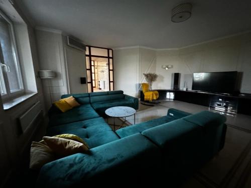 un soggiorno con divano blu e tavolo di Premium Residence SPA & Garden a Glińcz