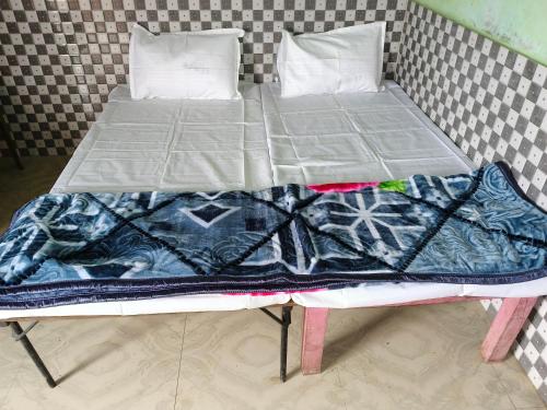 Una cama con dos almohadas encima. en Manglam house, en Ayodhya