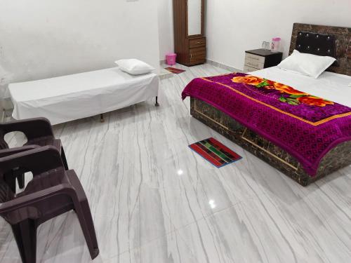 een slaapkamer met 2 bedden en paarse lakens op de vloer bij Manglam house in Ayodhya
