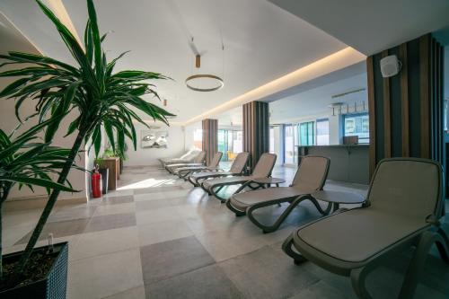 a waiting room with a row of chairs and a plant at Hotel Sato Conference & SPA Resort in Sutomore
