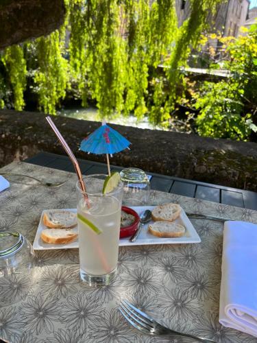 una mesa con una bebida y un plato de comida en Logis La Vieille Auberge, Art and Gallery, en Souillac