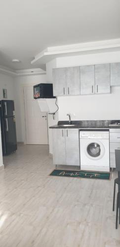 uma cozinha branca com um lavatório e uma máquina de lavar roupa em Studio In sky el Gandoul compound em Hurghada