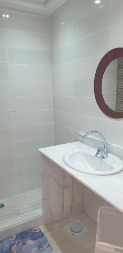 uma casa de banho branca com um lavatório e um espelho em Studio In sky el Gandoul compound em Hurghada