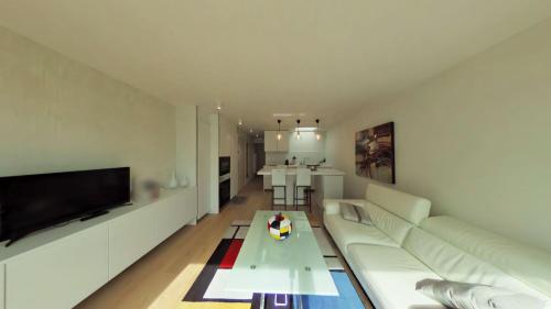 un salon avec un canapé blanc et une table dans l'établissement Anthea53, à Le Touquet-Paris-Plage