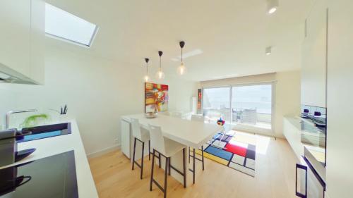 une cuisine blanche avec une table et des chaises blanches dans l'établissement Anthea53, à Le Touquet-Paris-Plage