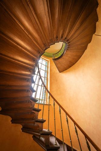a spiral staircase in a building with a wooden ceiling at Leyselebeke Castle in Bruges