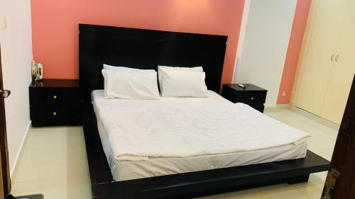 een bed met een zwart hoofdeinde in een kamer bij Serene Home Apartment (1-Bedroom) in Islamabad