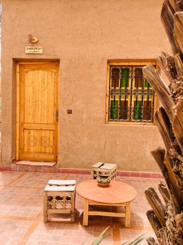 a table and two chests in front of a door at Camping auberge palmeraie d'amezrou in Zagora