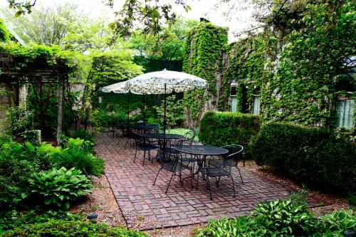 a patio with tables and chairs and an umbrella at The Winter Inn in Greenville