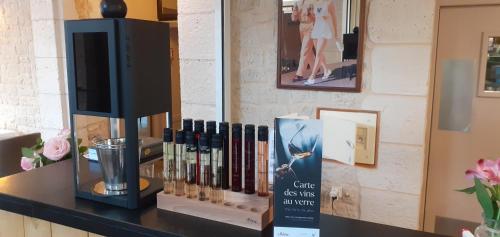 a counter with a tv and books on it at Logis Hôtel Restaurant La Vieille Auberge, Art and Gallery in Souillac