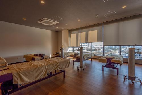 une chambre à l'hôpital avec des lits et une grande fenêtre dans l'établissement Tokyo Toyosu Manyo Club, à Tokyo