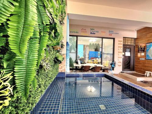 een zwembad met een groene muur bij Have FUN villa in Hengchun
