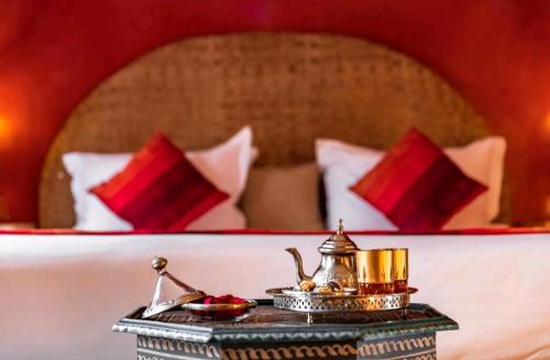 una mesa con una tetera encima de una cama en La Perle de l'Atlas by Golf Resort, en Marrakech