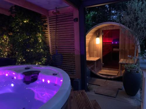 a jacuzzi tub in a backyard at night at Romantisch Wellness Appartement met privé Hottub Sauna Gamesroom in Den Ham
