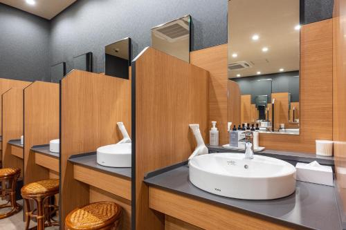a bathroom with two sinks and a mirror at Tokyo Toyosu Manyo Club in Tokyo