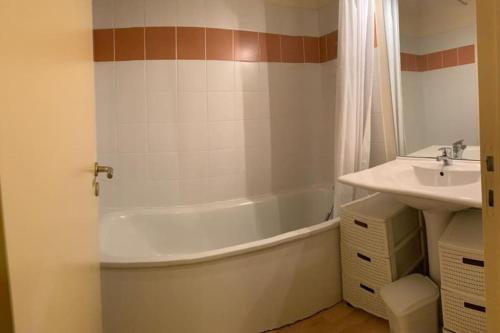 La salle de bains est pourvue d'une baignoire et d'un lavabo. dans l'établissement Résidence Les Iles Britanniques, à La Bourboule