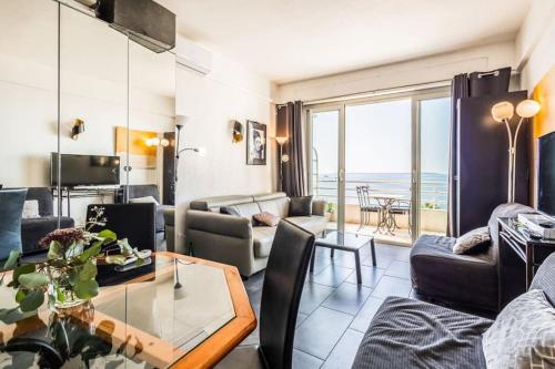 un salon avec un canapé et une table dans l'établissement Vue exceptionnelle - Ma terrasse sur le front de mer et - Studio 34 m2 - Antibes Juan-les-pins, à Antibes