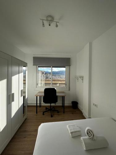 Cette chambre comprend un lit, un bureau et une fenêtre. dans l'établissement Hab en piso céntrico a 10min del lago, à Banyoles
