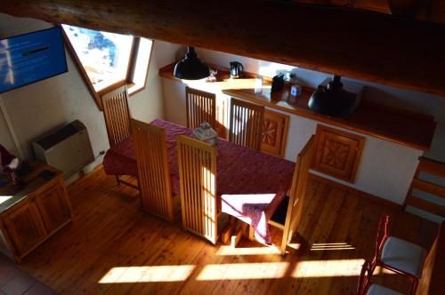 einen Blick über ein Zimmer mit einem Tisch und Stühlen in der Unterkunft Maison Chez Les Roset in Baulen
