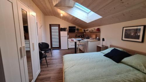 um pequeno quarto com uma cama e uma cozinha em Sous le saule em Nods
